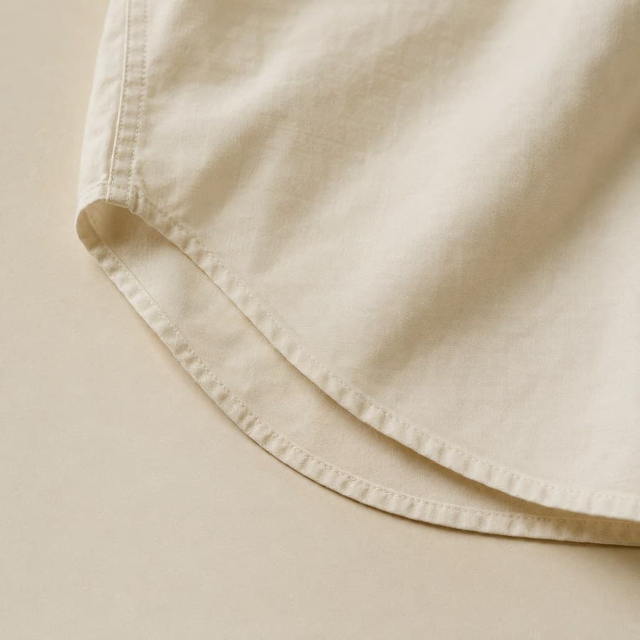Curved shirt hem sweeping across the plate