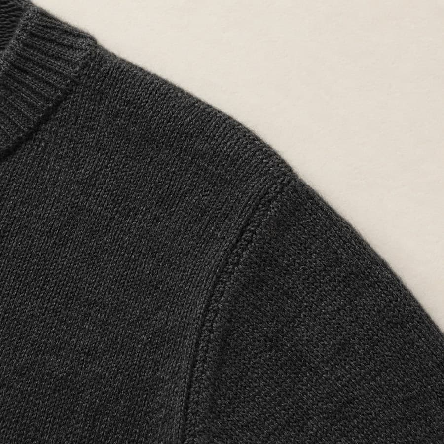 Shoulder seam on a charcoal knit, stitch structure visible