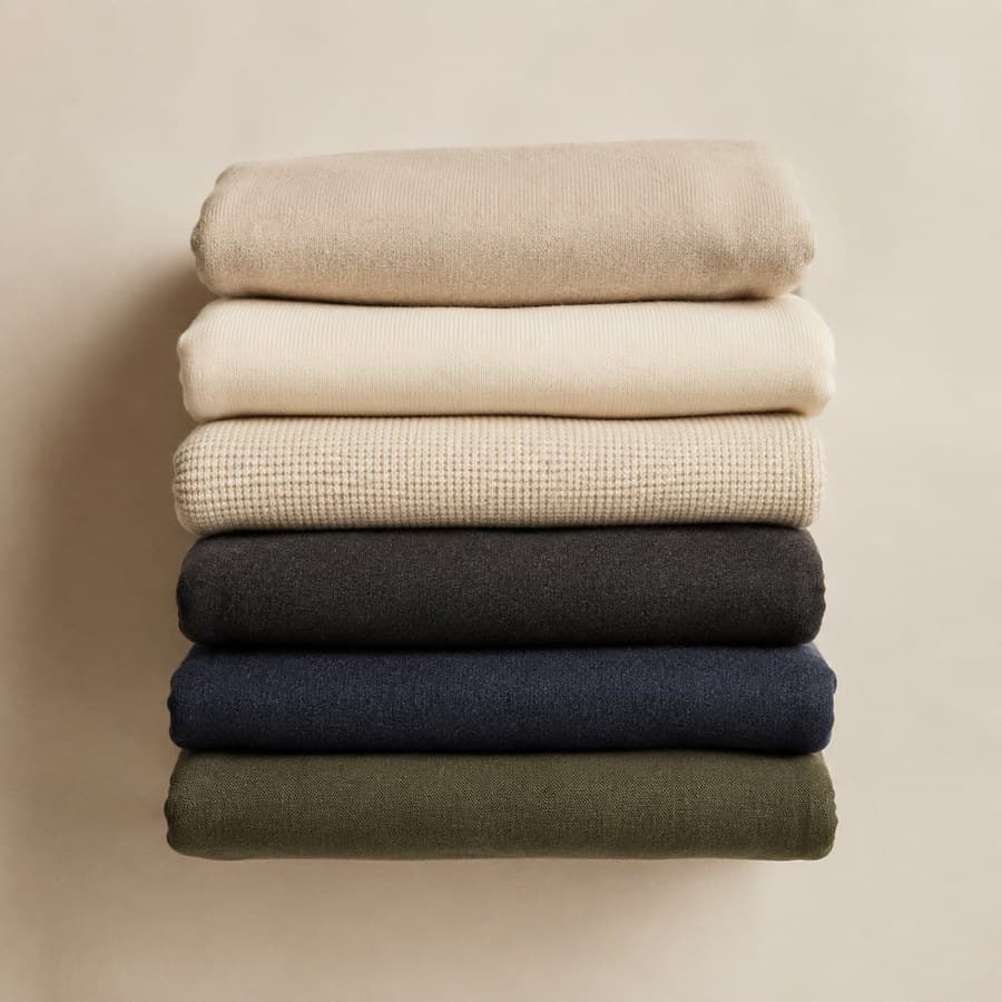 Six folded garments stacked with their edges aligned, seen from above